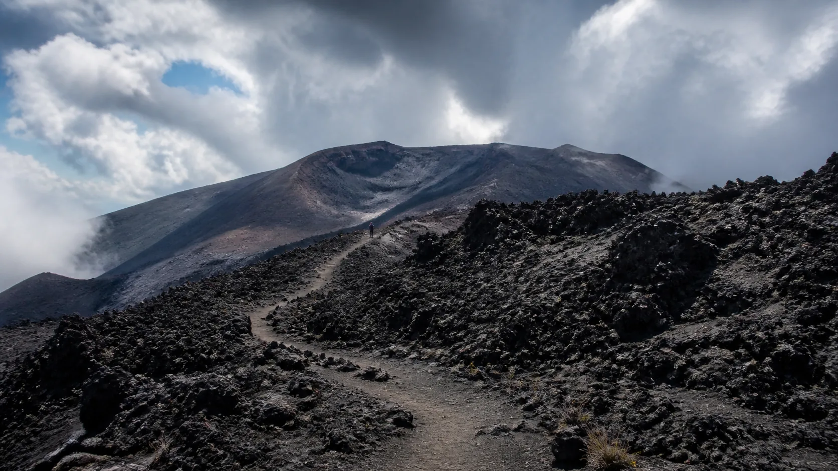 Wanderer am Aetna mit Lava-Felsen und Krater