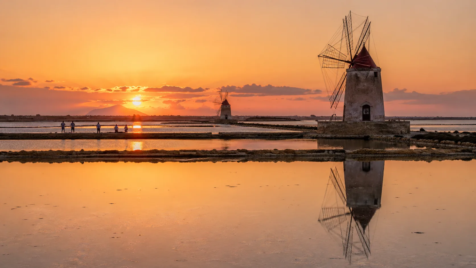 Salinen mit Windmühlen bei Sonnenuntergang in Trapani